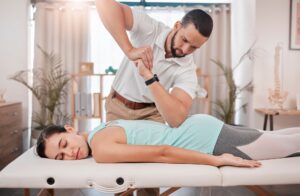 Chiropractor, massage and physiotherapy treatment for back and smile with a woman patient. Consulti